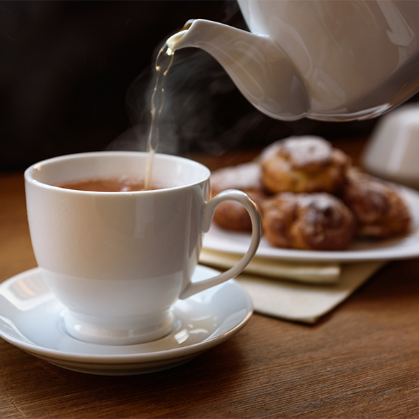 eclairs with custard cream with tea and teapot